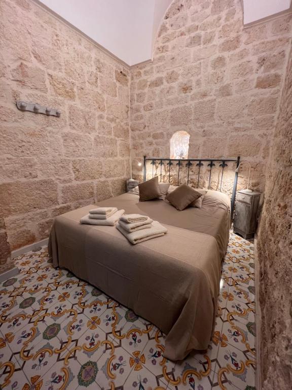 een slaapkamer met een bed in een bakstenen muur bij Casa Mirabilis 44 in Ostuni