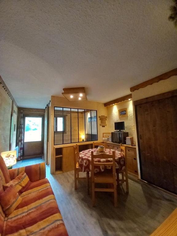 a living room with a table and a kitchen at Chalet Campanule in Bonneval-sur-Arc