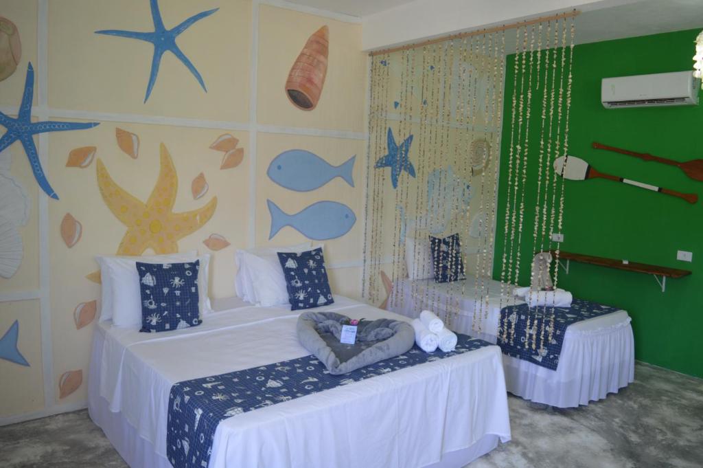 2 camas en una habitación con estrellas en la pared en Pousada Vila Vovo Zilda, en Maragogi