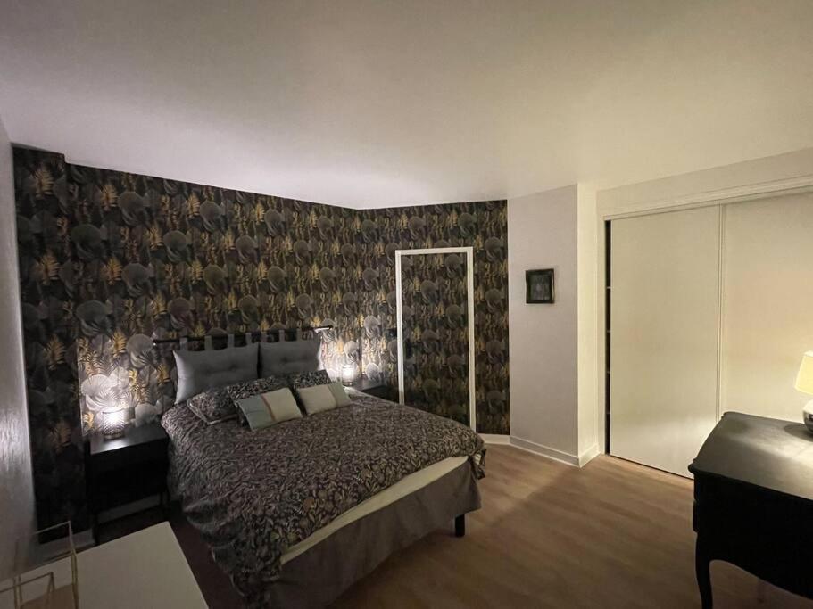une chambre avec un grand lit et un mur dans l'établissement Stade Rochelais, à La Rochelle