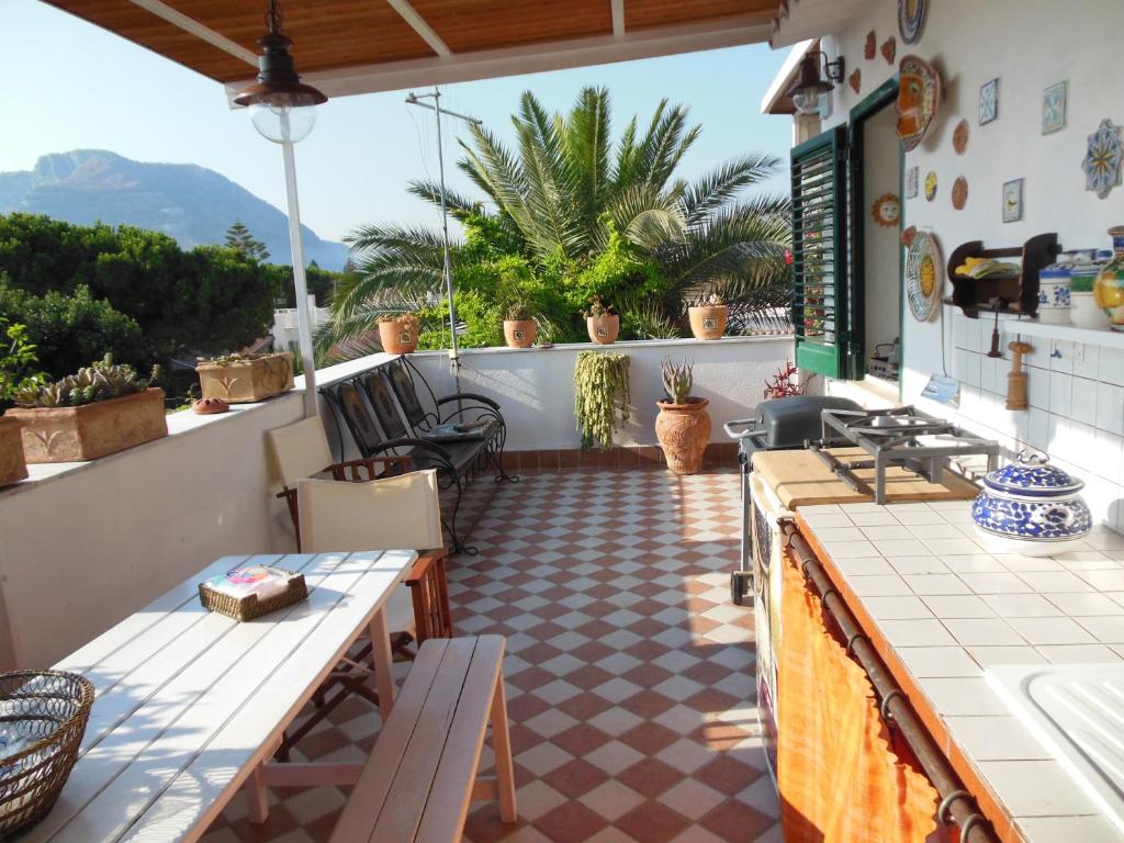 un patio con mesas y sillas en el balcón en Casa Lunastella Locazione Turistica, en Mondello