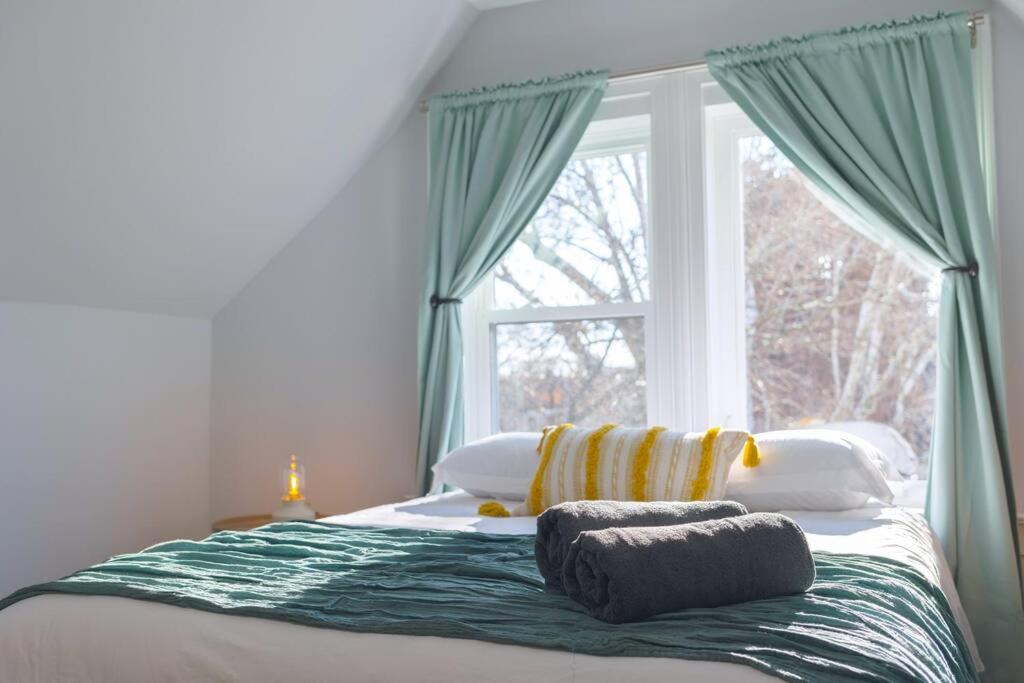 een bed met kussens en een raam in een slaapkamer bij Sunshine Central - Yale 3BR Prking Wshr/Dryr in New Haven
