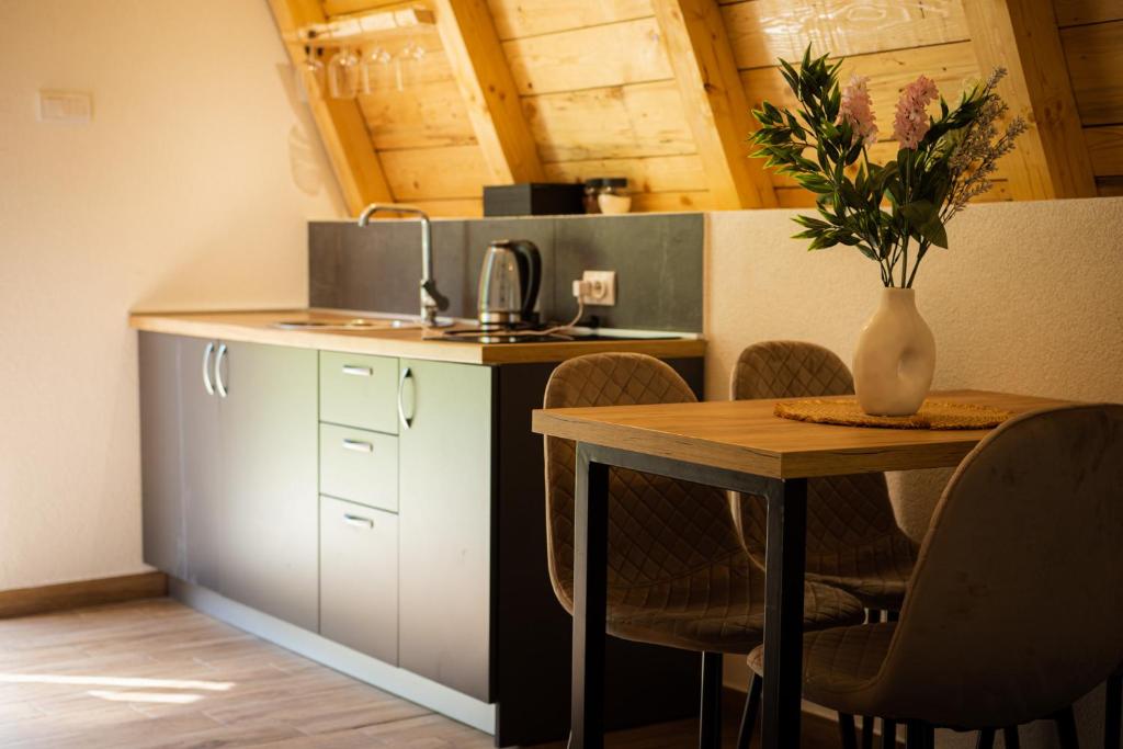 a kitchen with a table and a vase with flowers on it at Natures Escape Kozarica in Šavnik