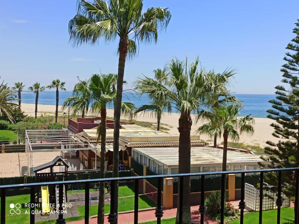 uma vista para a praia a partir da varanda de um resort em Alcaudón 1 dormitorio by SIT ISLA CANELA em Isla Canela
