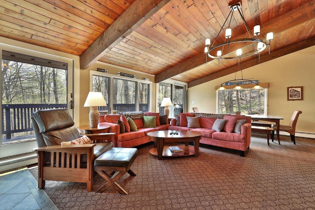 a large living room with red couches and tables at Alpine Court Chalet home in Killington