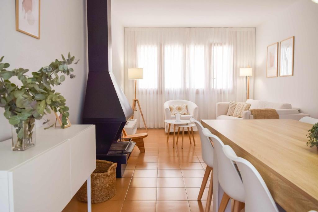 een woonkamer met een tafel en witte stoelen bij Can Falga Alojamiento en el corazón de Besalú in Besalú
