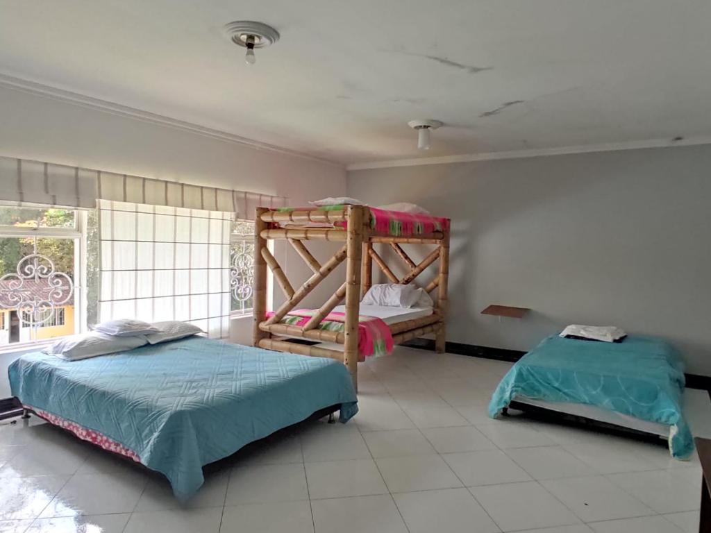 a bedroom with two bunk beds and a window at Hotel Centro Recreacional Valle deEli in Fusagasuga