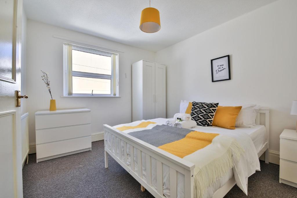 ein weißes Schlafzimmer mit einem Bett und einem Fenster in der Unterkunft StayRight 2 Bed Central Flat- 10 mins walk to Castle & Centre in Cardiff