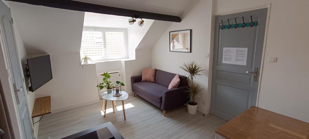 un salon avec un canapé violet et une table dans l'établissement Centre ville à 2 pas de la plage, à Pornichet