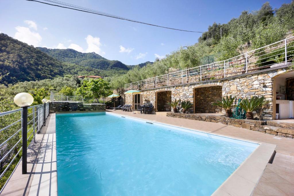 ein Schwimmbad in einem Haus mit Bergen im Hintergrund in der Unterkunft La Cicala 1 in Stellanello
