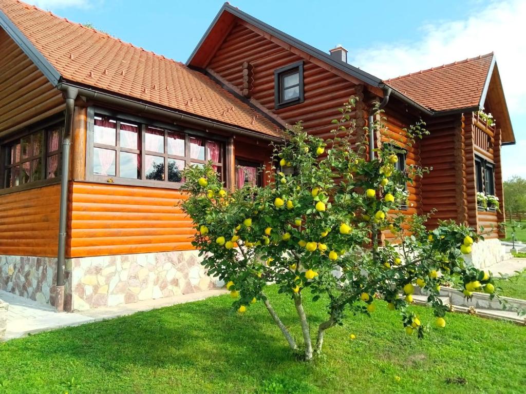 an orange tree in front of a house at Ruralna kuća za odmor Marta in Otočac