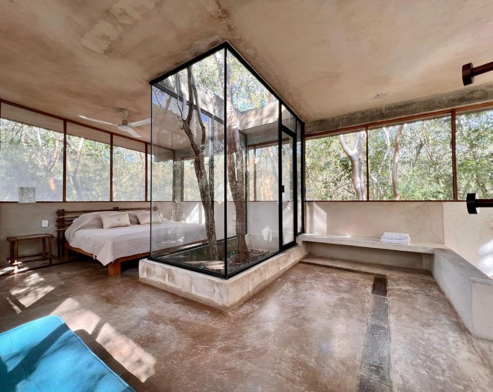 a room with a glass shower and a bed in it at El Encanto - Hotel Boutique in Chichén-Itzá