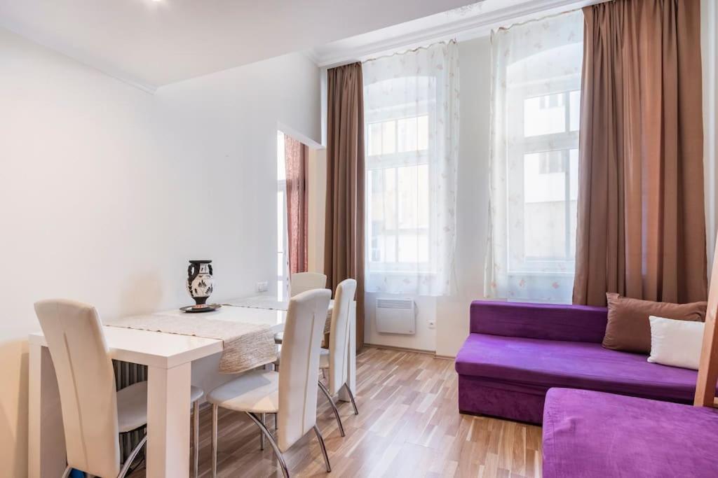 a living room with a table and a purple couch at Apartment on Masaryka 39 in Karlovy Vary