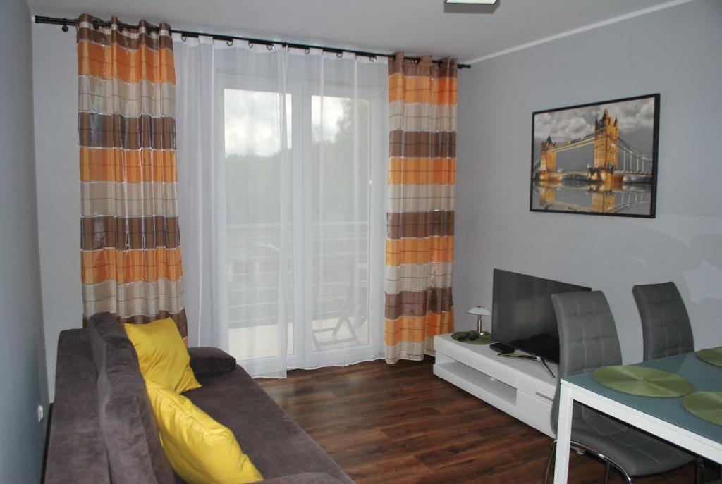 un soggiorno con divano e tavolo da pranzo di Apartament Zwyciezcow a Polanica-Zdrój