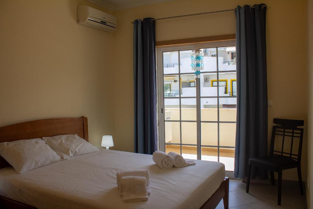 Un dormitorio con una cama con toallas y una ventana en Leta´s Beach House en Carvoeiro