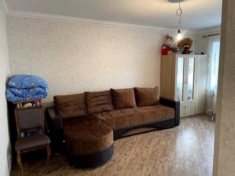 uma sala de estar com um sofá castanho e uma cadeira em Aram Guest House em Sevan