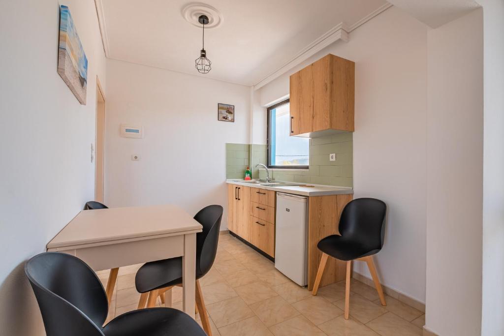 a kitchen with a table and chairs in a room at Anthia Apartments in Marmari