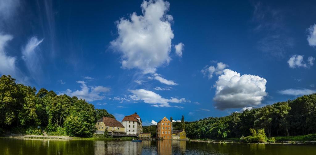 a group of buildings on the shore of a lake at Hotel Obermühle in Görlitz