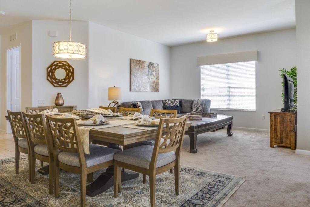 een eetkamer en een woonkamer met een tafel en stoelen bij Penthouse Utopia condo in Orlando