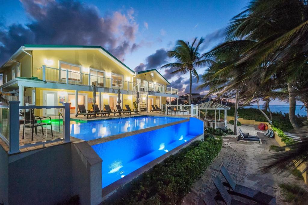 a house with a swimming pool next to the beach at Fischers Reef by Grand Cayman Villas & Condos in Driftwood Village