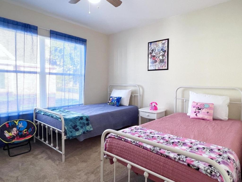 1 dormitorio con 2 camas y ventana en 4 Bedroom Town Home Near Disney townhouse en Kissimmee