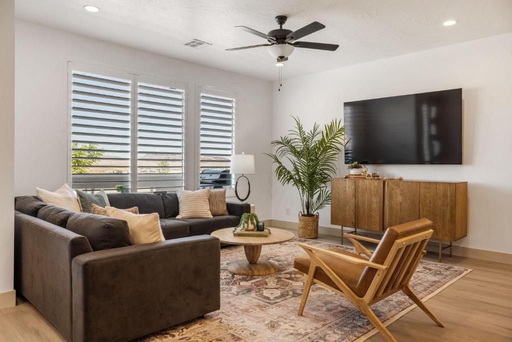 a living room with a couch and a flat screen tv at Lagoon Vibes townhouse in St. George