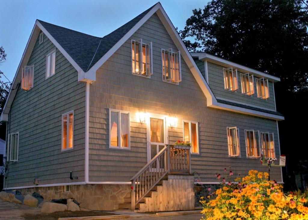 a gray house with lights on the front of it at COZY COVE COTTAGE LIMIT 6 cottage in Standish