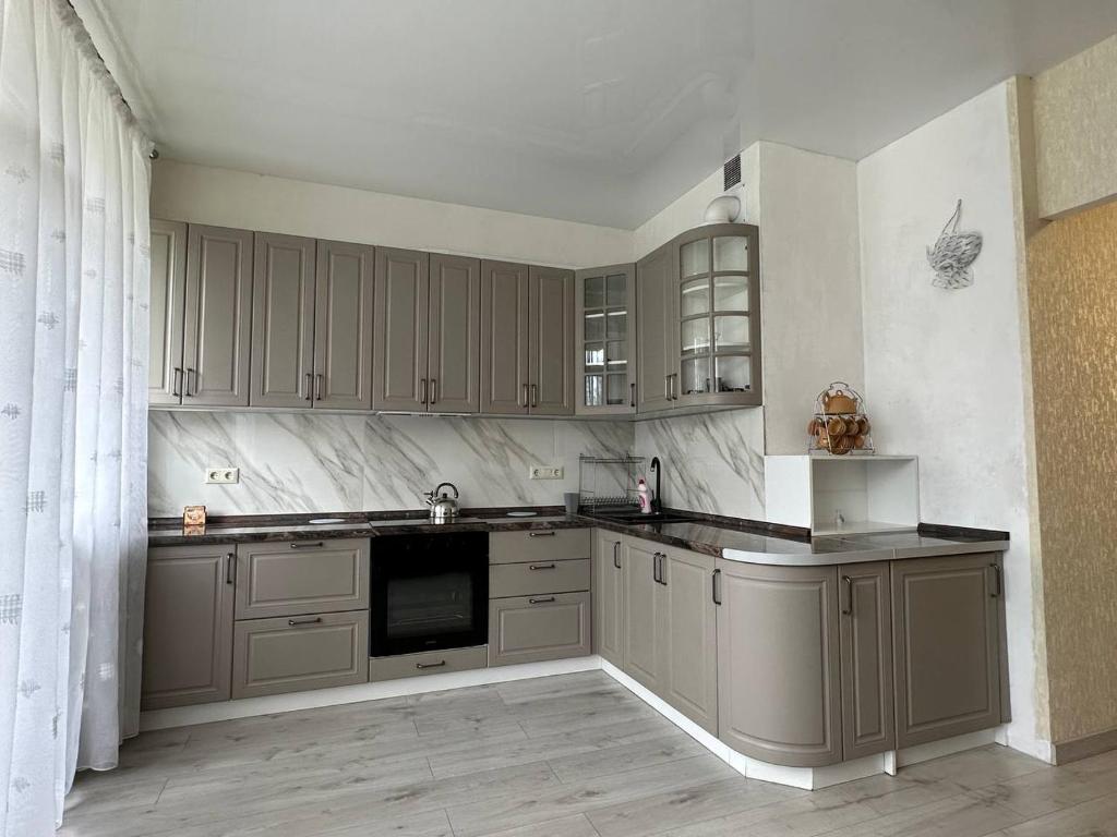 een keuken met grijze kasten en een aanrecht bij Altair apartments Budova in Odessa