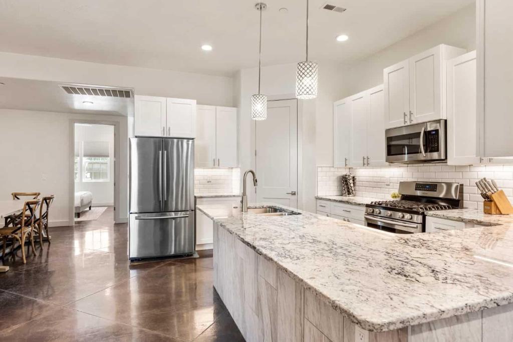 a kitchen with white cabinets and a marble counter top at Highlander townhouse in Hurricane