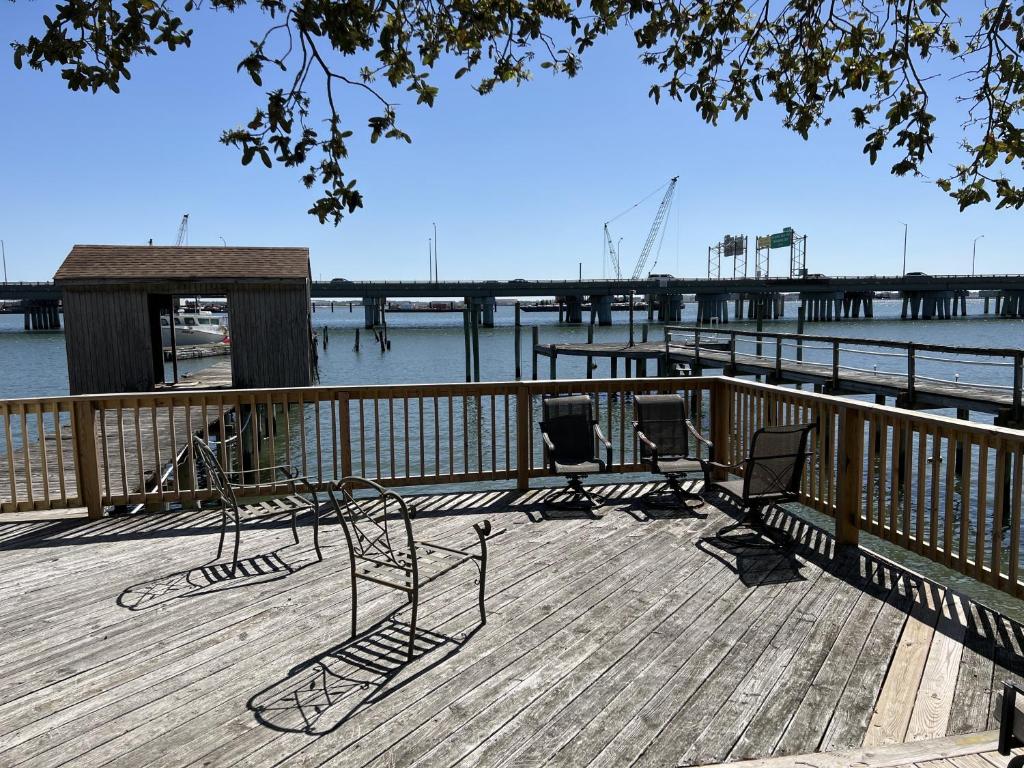 a wooden deck with chairs on a dock next to the water at Water Front Oasis home in Norfolk
