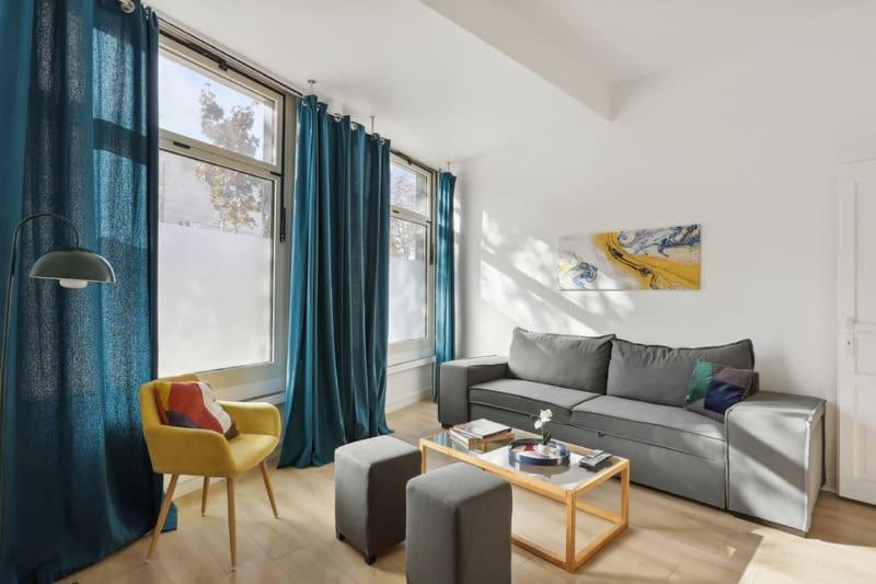 a living room with a couch and a table at Cosy renovated studio in heart of Paris XVieme in Paris