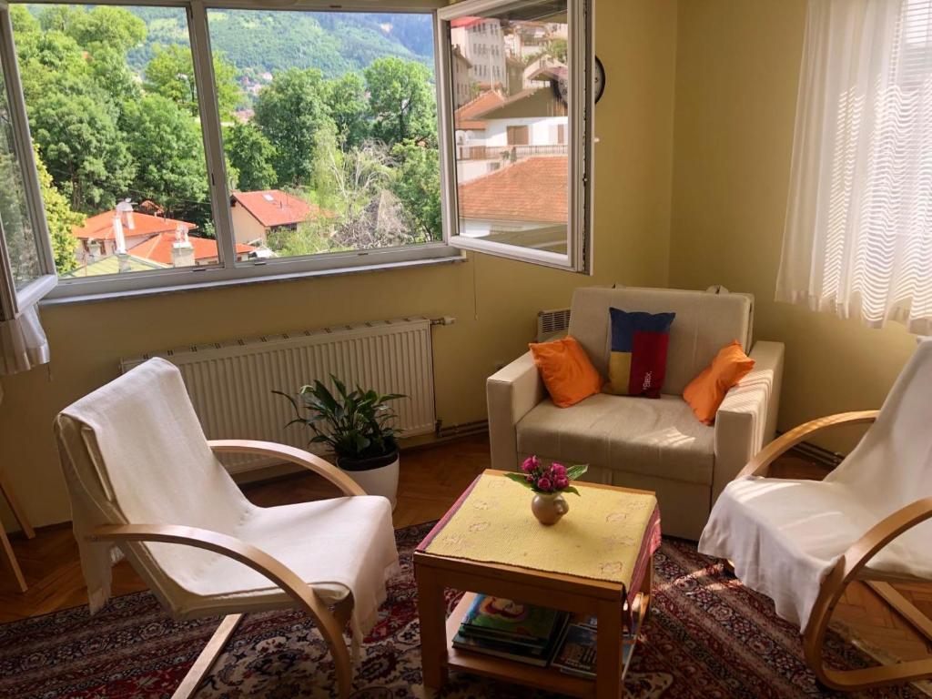 a living room with chairs and a table and a window at Hedgehog's Home - Ježeva kućica Free Parking in Sarajevo