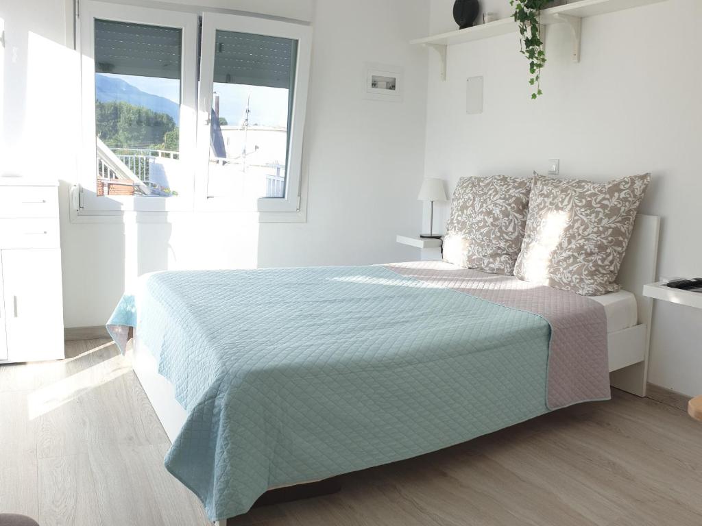 - une chambre blanche avec un lit et une fenêtre dans l'établissement Skyview Studio, à Kerkíni