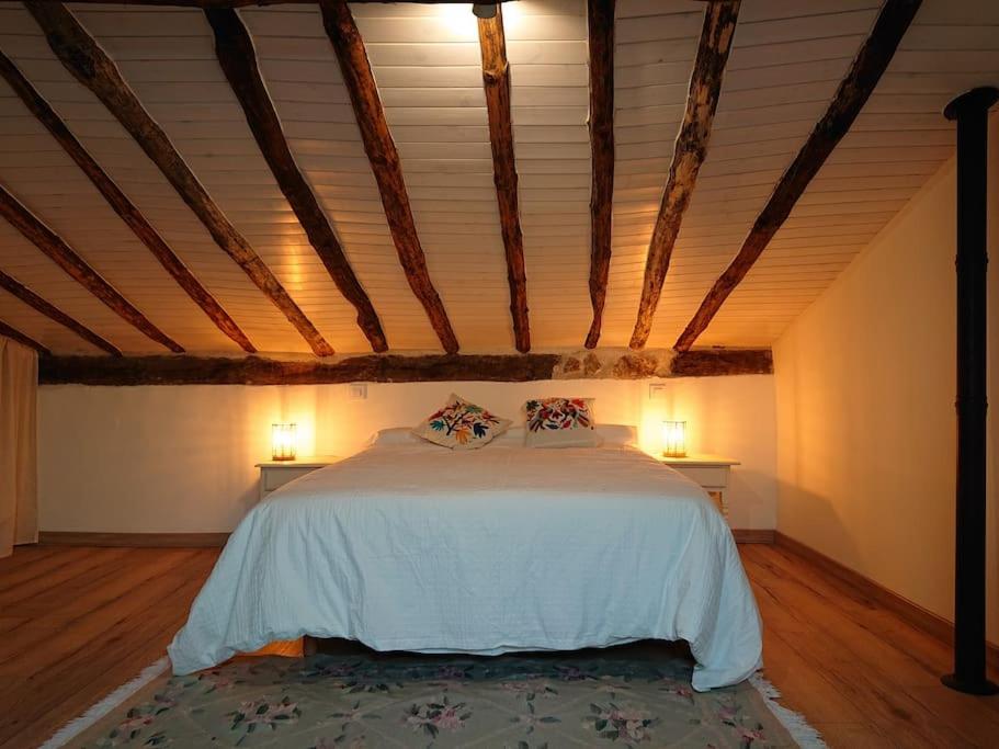 ein Schlafzimmer mit einem großen Bett im Dachgeschoss in der Unterkunft Casa Pozo Tarama in Casavieja