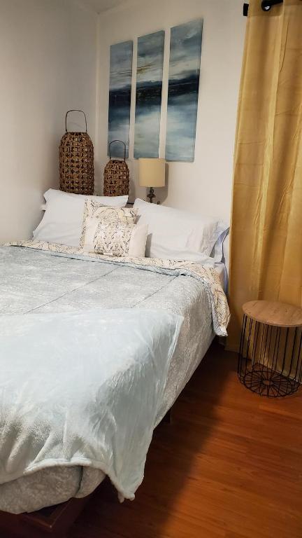 a bedroom with a bed with white sheets and a table at Cozy one bedroom condo in Corpus Christi