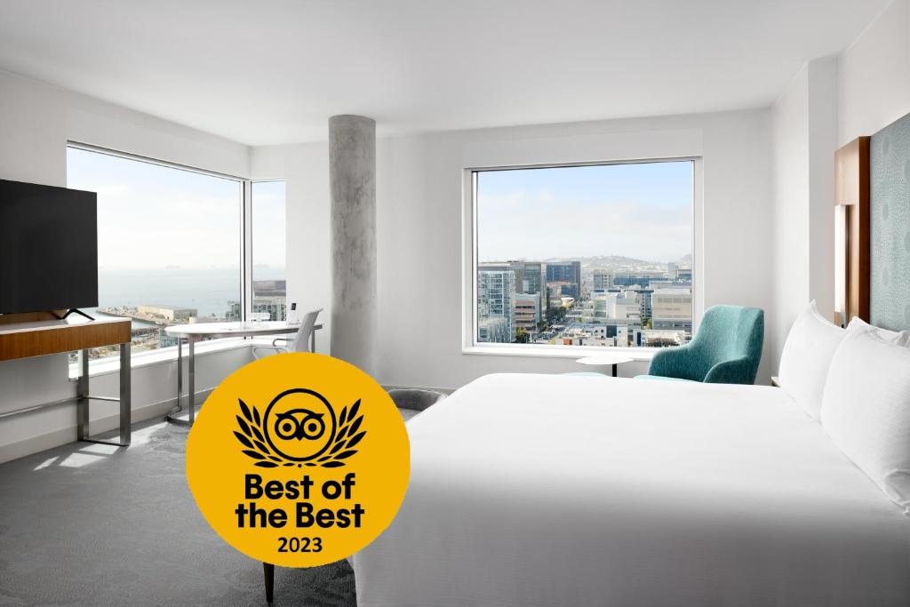 LUMA Hotel San Francisco - #1 Hottest New Hotel in the US 2023 في سان فرانسيسكو: غرفة نوم مع سرير مع علامة تقرأ أفضل من الأفضل