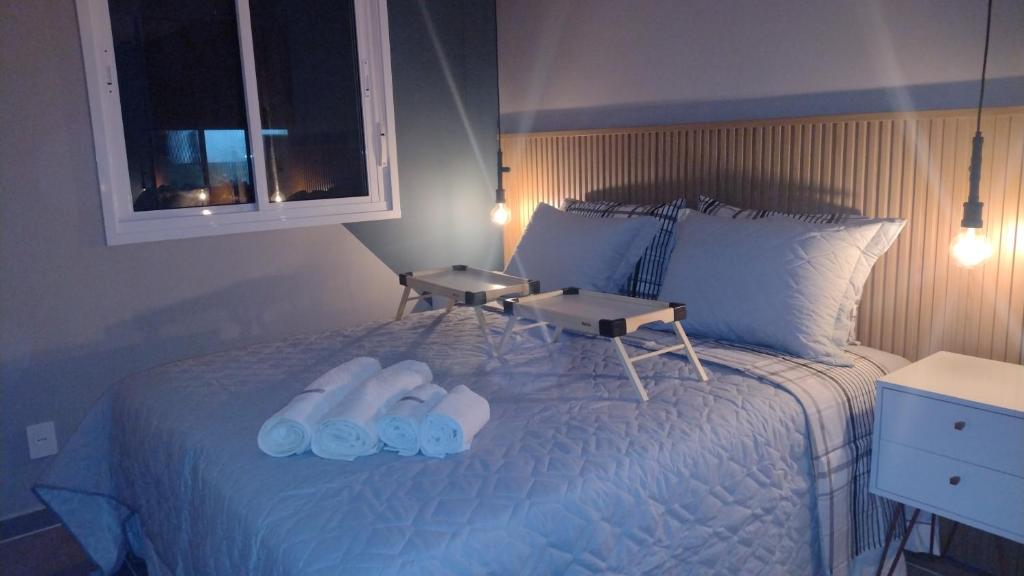 ein Schlafzimmer mit einem Bett mit zwei Hausschuhen darauf in der Unterkunft Paraiso Paulista Premium in São Paulo