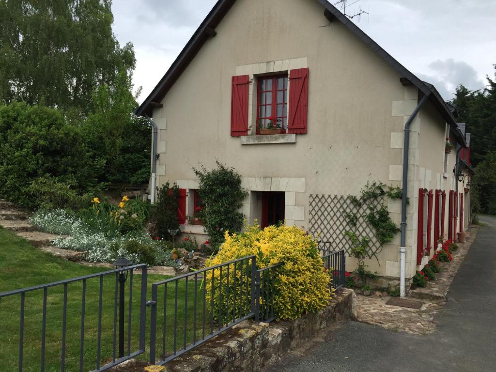 une maison blanche avec des fenêtres rouges et une clôture dans l'établissement Maison de campagne entre Loire et vignes, à  Charcé-Saint-Ellier-sur-Aubance