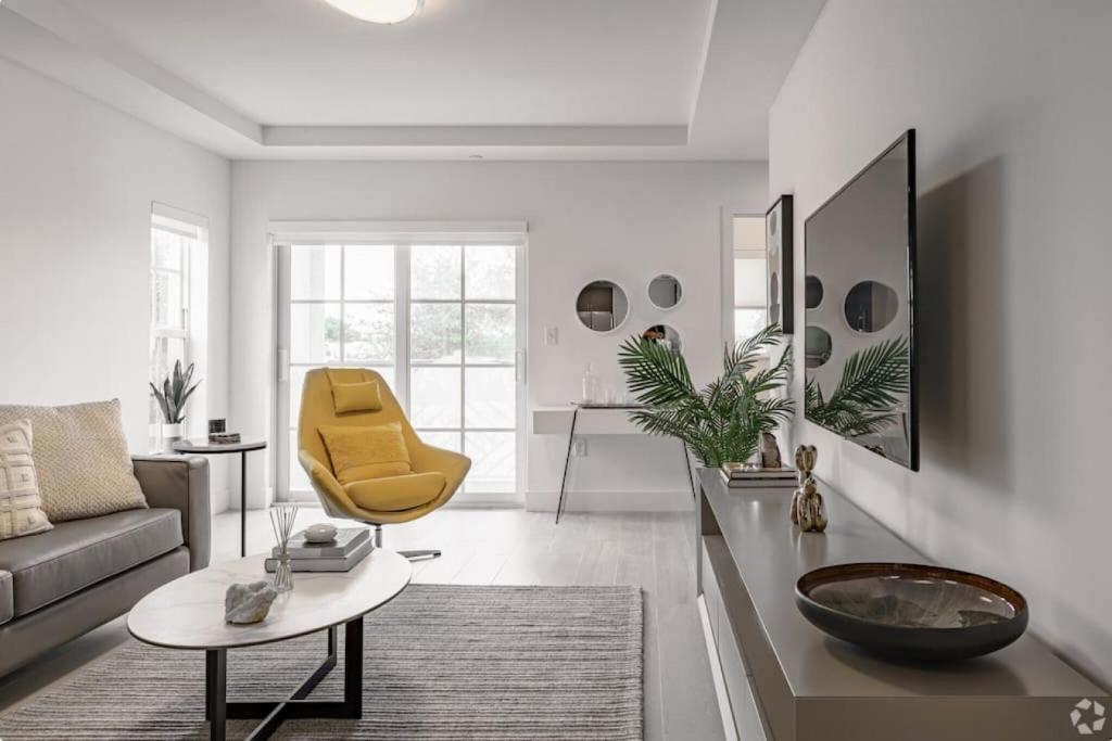 a living room with a couch and a yellow chair at Dahlia - The Designer Townhome in Lake Worth
