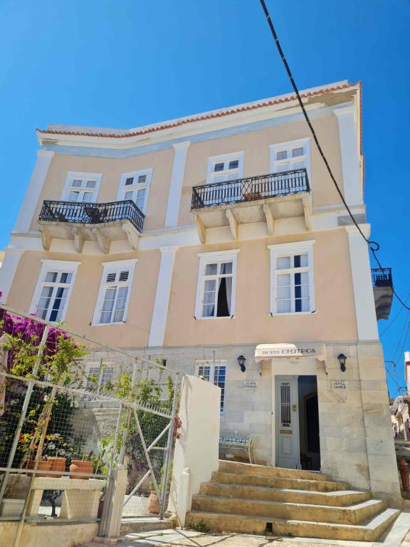 a large white building with stairs in front of it at Hotel Omiros in Ermoupoli