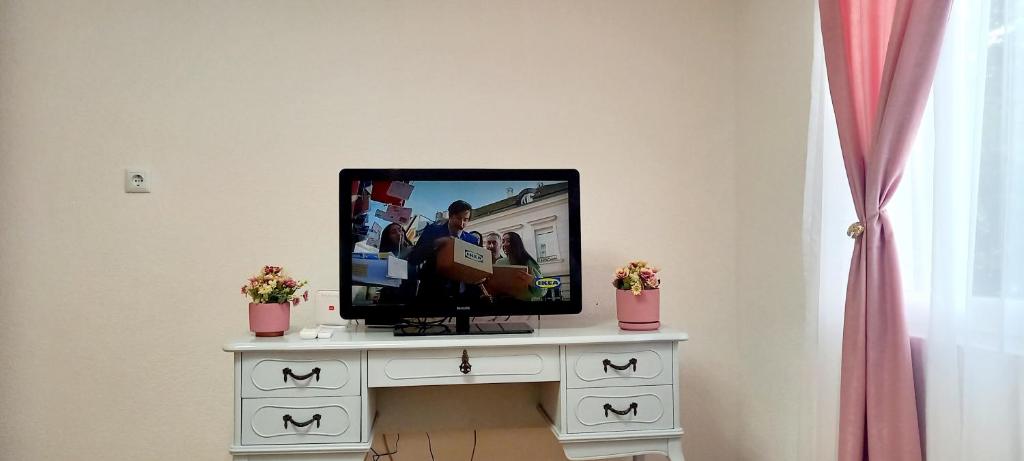 uma televisão de ecrã plano sentada numa cómoda branca em Carmen apartman em Brcko