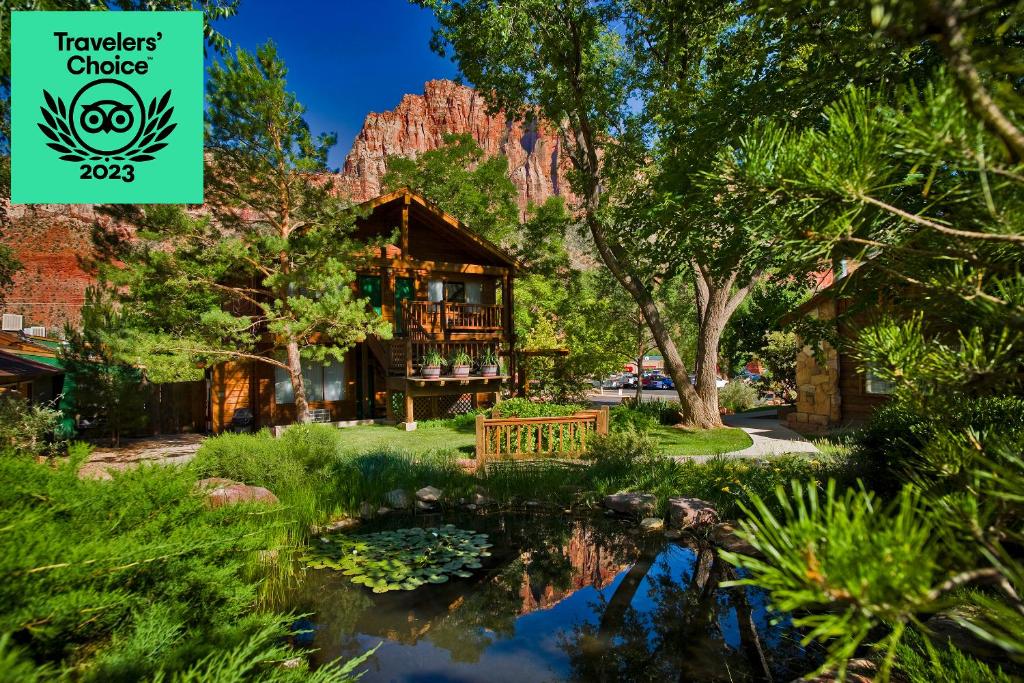 a lodge with a pond in front of a mountain at Flanigan`s Resort and Spa in Springdale