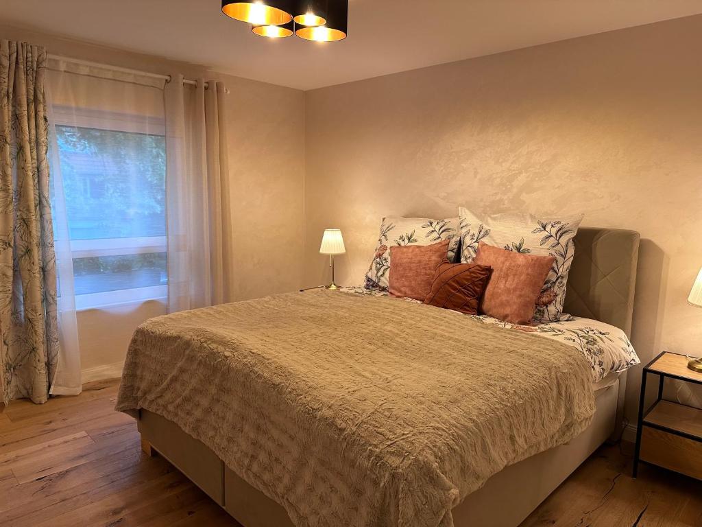 una camera da letto con un letto con cuscini e una finestra di FeWo by HD mit Parkplatz, Wallbox, Wintergarten a Bad Salzuflen