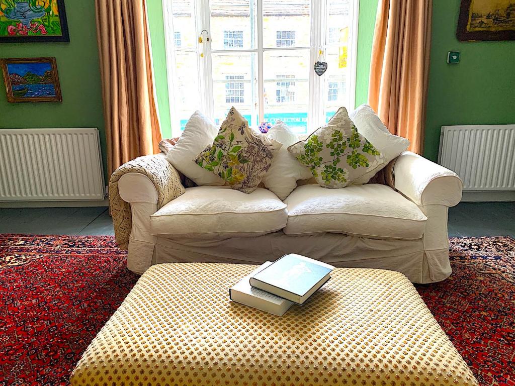 a living room with a couch with a book on a table at Spacious Georgian Apartment, Central Barnard Castle. in Barnard Castle