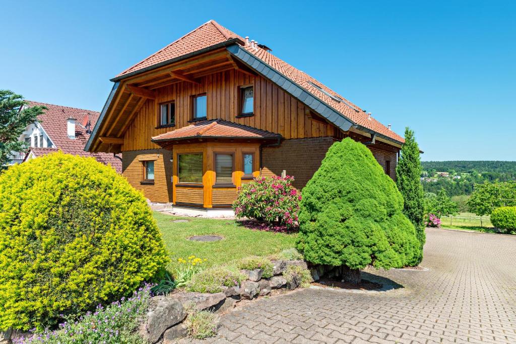 ein Holzhaus mit Büschen davor in der Unterkunft Haus Erlenmaier in Schömberg