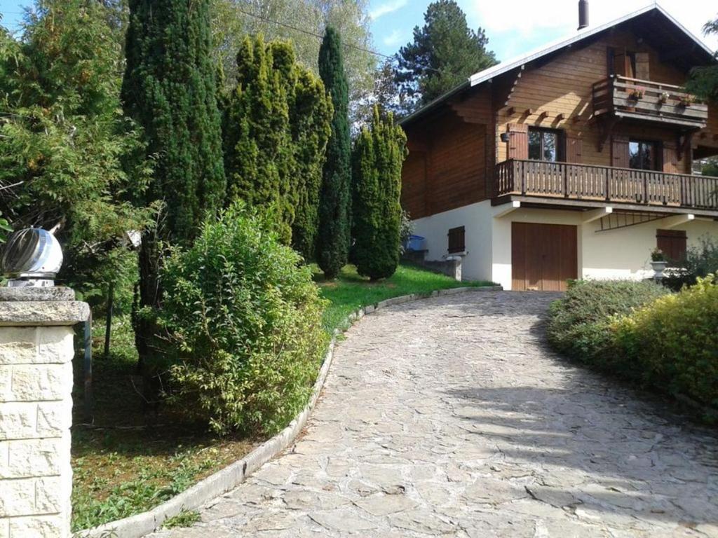 ein Haus mit einem Balkon und einer Auffahrt in der Unterkunft Chalet Jura in Doucier