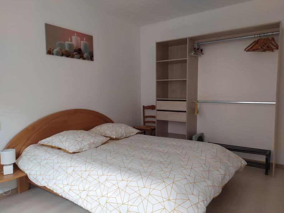 a bedroom with a bed and a refrigerator at Chez Christine et Philippe in Fontvieille