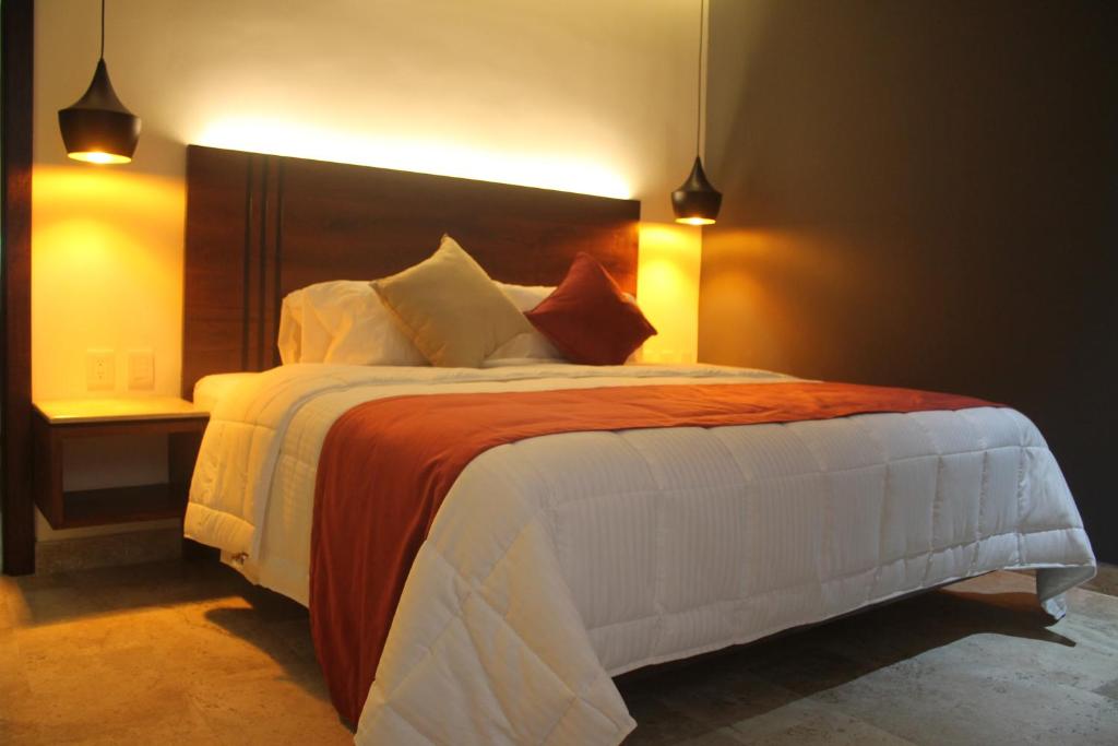 1 dormitorio con 1 cama grande en una habitación en Hotel veinti 3 Tapachula, en Raymundo Enríquez