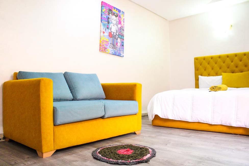 Akwaba lodge في ساليه: غرفة معيشة مع أريكة وسرير