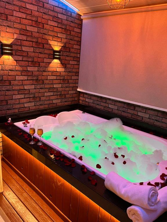 a jacuzzi tub filled with green liquid at Cabanas Brisa dos Canyons in Cambará